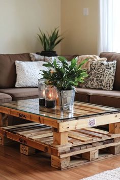 a coffee table made out of wooden pallets with candles on top and plants in the middle