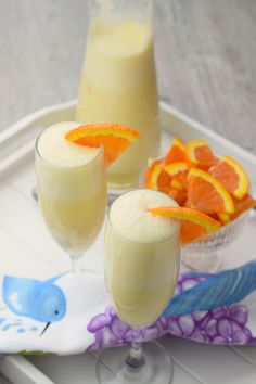 two glasses filled with orange juice on a tray