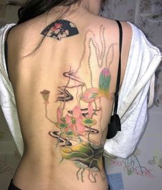 the back of a woman's body with tattoos on it