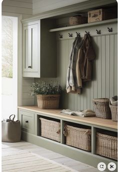 a coat rack with baskets and coats hanging on the wall next to it is an entryway