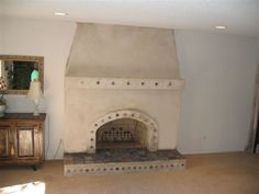 a living room with a fire place in the center and a mirror on the wall