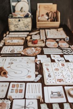 the table is covered with cards and sewing supplies