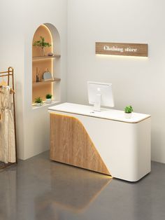 a white desk with a laptop on it in front of a clothing store display case