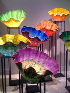 several colorful glass bowls on display in a room