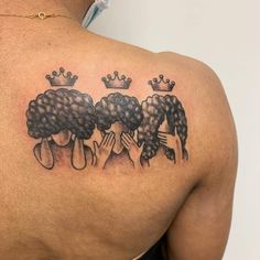 the back of a woman's shoulder with three poodles and crowns on it