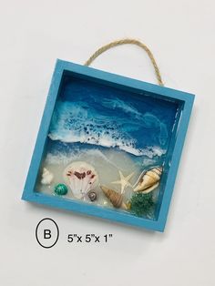 a blue box with seashells and starfish on the beach