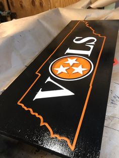 an orange and black street sign sitting on top of a table