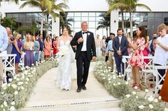 a bride and groom walking down the aisle