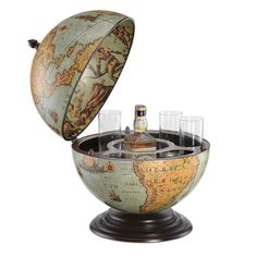 an old world globe with wine glasses in it