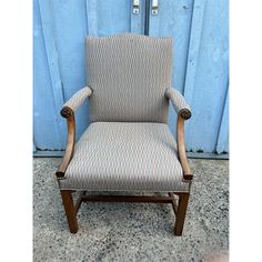 a chair sitting in front of a blue wall with two handles on each arm and the seat up