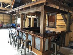 an old fashioned bar with stools and barstools in a barn like setting