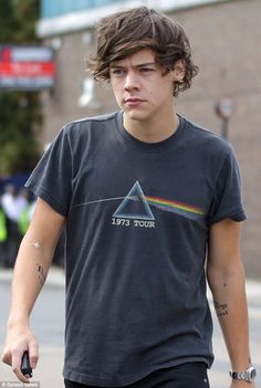 a young man walking down the street wearing a dark side of the moon t - shirt