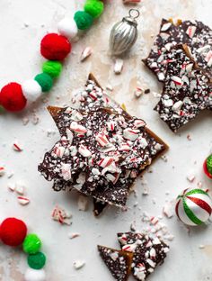 christmas brownies with candy canes and peppermint on top, surrounded by other holiday treats