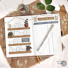 an open planner book on top of a table next to a cup of coffee and a pair of scissors