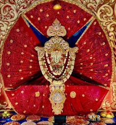 an elaborately decorated red cloth with gold decorations on the head and shoulders, surrounded by other decorative items