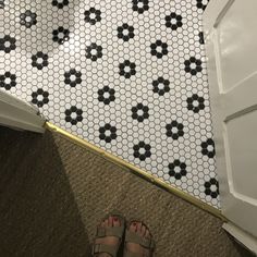 a person standing in front of a door with their feet up on the tile floor