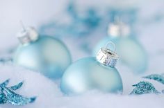 three blue christmas ornaments sitting in the snow