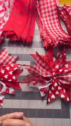 red and white paper flowers are being cut