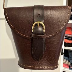 a brown leather purse hanging from a hook