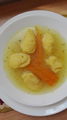 a white bowl filled with soup on top of a wooden table