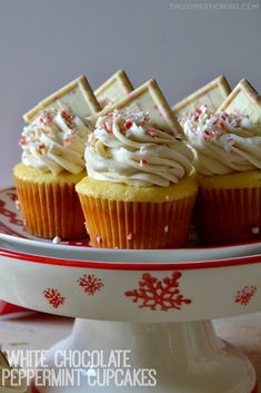 cupcakes with white chocolate frosting and sprinkles on a plate