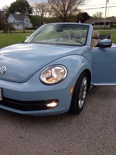 a blue convertible car parked in a parking lot