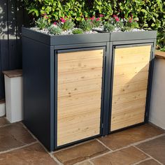 two wooden planters sitting next to each other on top of a brick floored patio