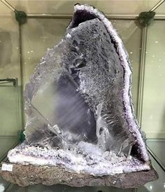 a large piece of rock sitting on top of a glass case filled with ice and snow