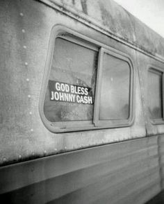 a black and white photo of the side of a train with an ad on it