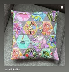 a colorful pillow sitting on top of a gray couch