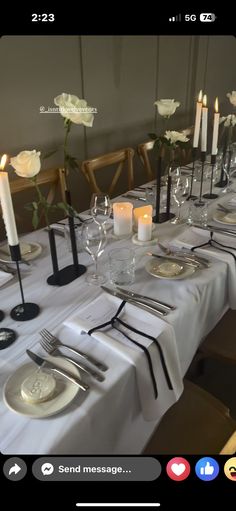 the table is set with white roses and candles for an elegant dinner or special event