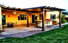 an outdoor patio with chairs and tables in the evening sun, next to a house