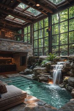 an indoor swimming pool with waterfall in the middle and large windows on both sides that look out onto trees