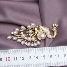 ORIGINAL DESIGNED: Round peacock Pearl Lapel Pin Brooch; designed by nature-originated jewelry designer in the team 1950s VINTAGE STYLE: the brooches creates a sense of 1950s and brings you antique fashion looking DETAILS: ornamented with pearls and crystal, the pins are young, shining, and easy to maintain, Freshwater pearl. STYLES: 3 SIZE: 80 x 40 mm A must-have in your wardrobe essentials! Wear it casually with your linen blazer or even to an important event Add an element of style and color Elegant Peacock-colored Brooches For Wedding, Elegant Peacock Brooches For Wedding, Wedding Brooch With Peacock Design, Elegant Wedding Brooch With Peacock Design, Elegant Peacock Design Brooch For Wedding, Elegant Peacock Color Wedding Brooches, Elegant Peacock Design Wedding Brooch, Peacock Colored Wedding Brooch Jewelry, Elegant Peacock Design Brooch For Formal Occasions