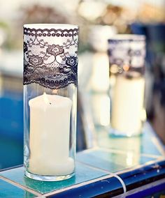 a candle that is sitting in a glass vase on top of a blue tile table