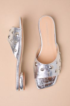 The Intentionally Blank Sadie Mercury Silver Leather Studded Slide Sandals are eye-catching and modern, which is the perfect combination for gathering compliments! Shiny, textured genuine leather shapes these stunning sandals that feature a single sole silhouette, a trendy square toe bed, and a wide toe strap embellished with mesmerizing silver studded details (of varying sizes). The sleek slide-on design will make these your go-to shoes for effortless styling! Available in Euro sizes only. 0. 7 Modern Flat Heel Sandals For Party, Glamorous Leather Sandals With Low Heel, Modern Silver Open Toe Mules, Chic Block Heel Sandals With Textured Sole, Leather Flat Heel Sandals For Party, Flat Heel Leather Sandals For Party, Silver Open Toe Mules With Removable Insole, Modern Leather Heels With Textured Footbed, Trendy Silver Open Toe Mules