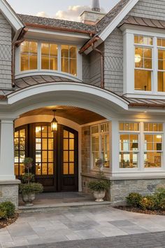 the front entrance to a house with large windows