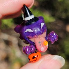 a small purple and orange figurine with a witches hat