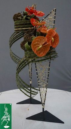 there is a sculpture made out of wire with flowers in it on top of a table