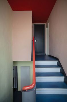 the stairs are painted blue and white with red handrails on each one side