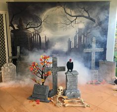 a halloween scene with tombstones, skulls and a crow sitting on top of them