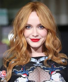 a woman with red hair and blue eyes is posing for the camera at an event