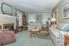 a living room filled with furniture and a fire place in the middle of a room