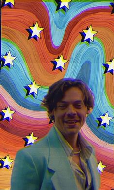 a man is smiling in front of an artistic background with stars and swirls on it