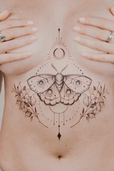 a woman's stomach with a butterfly tattoo on her chest and the moon above it