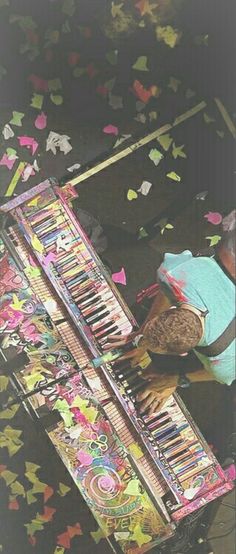 a person sitting at a piano surrounded by confetti