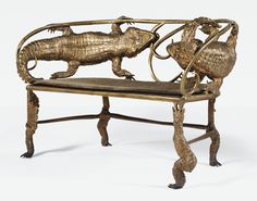 an ornate wooden bench with lizards on it's back legs and foot rests