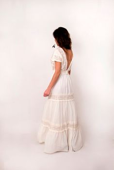 a woman in a white dress is looking back