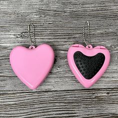 two pink and black hearts hanging from chains