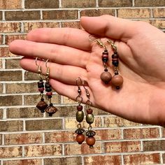 This set of three earrings are made of wooden beads harvested from vintage jewelry. Their design is abstract and geometric, but their material elicits natural beauty and wildlife. Your order includes all three pairs pictured. They are perfect for wearing in pairs, or mixing and matching! Wooden Beads Earrings, Bohemian Wooden Bead Earrings, Artisan Brown Earrings With Wooden Beads, Brown Wooden Bead Earrings, Unique Brown Wooden Beads Earrings, Unique Brown Earrings With Wooden Beads, Wooden Beads Jewelry, Wood Bead Earrings, Three Earrings